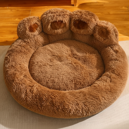 45-degree front angle view of caramel brown bear paw dog bed in home interior setting