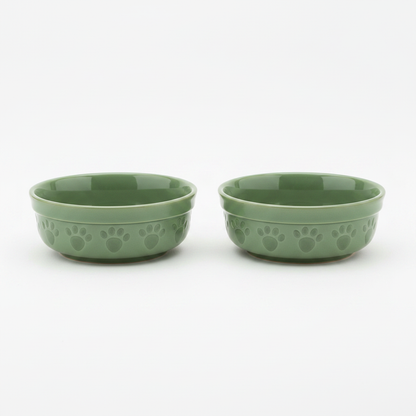 Set of two sage green ceramic pet bowls with paw print pattern