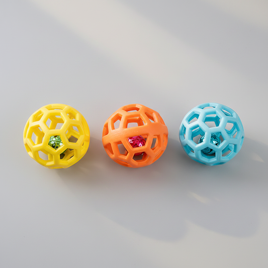 Three hollow lattice rubber pet toy balls in yellow, orange and sky blue grouped together